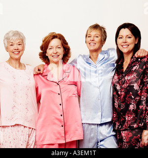 Portrait of three mature women and a senior woman standing together and smiling Stock Photo