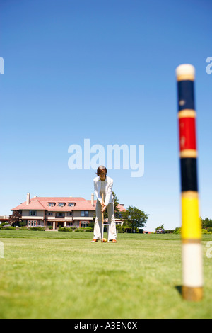 Mid adult woman playing croquet in a playing field Stock Photo