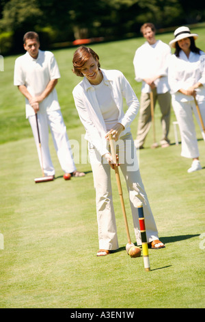 Mid adult woman playing croquet with a mature couple and a mid adult man standing behind her Stock Photo