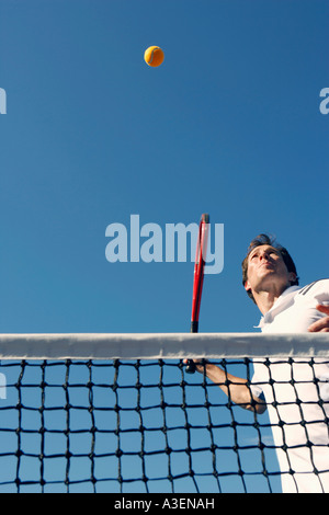 Low angle view of a mid adult man playing tennis Stock Photo