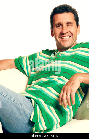 Portrait of a mature man reclining on a couch and smiling Stock Photo