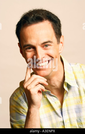 Portrait of a mature man smiling with his hand on his chin Stock Photo