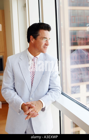Close-up of a businessman looking through a window Stock Photo