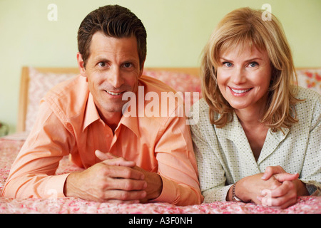 Portrait of a mature couple lying on the bed and smiling Stock Photo