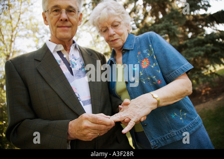 Man placing ring on finger Stock Photo