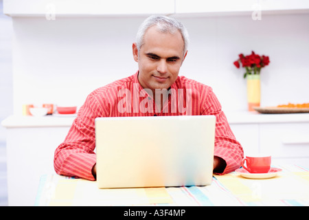 Mid adult man using a laptop Stock Photo
