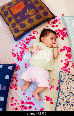 High angle view of a baby girl lying on the bed and sucking his thumb Stock Photo