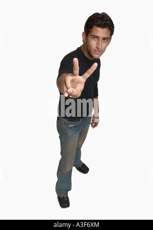 Portrait of a young man showing the peace sign Stock Photo
