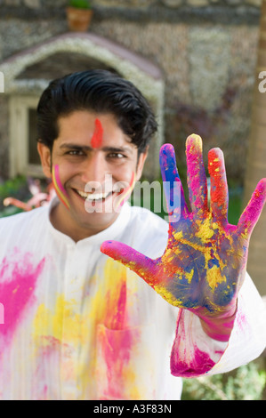 Portrait of a young man showing powder paint on his palm and smiling Stock Photo