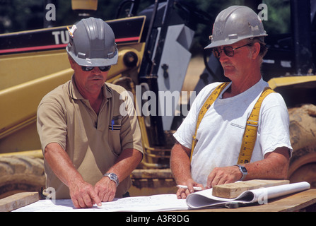 Engineer Pointing Out Detail on Blueprint To Construction Supervisor at Job Site United States Stock Photo