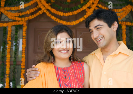 Young couple smiling in front of a closed door Stock Photo