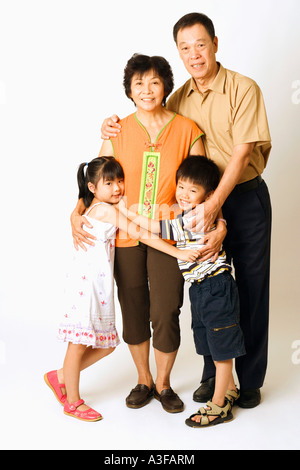 Portrait of a senior man and a mature woman standing with their grandchildren Stock Photo