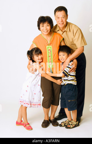 Portrait of a senior man and a mature woman standing with their grandchildren Stock Photo