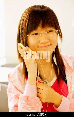 Close-up of a teenage girl listening to an MP3 player in the classroom Stock Photo