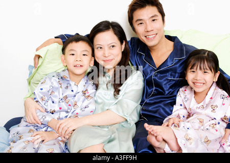 Close-up of a mid adult man and a young woman smiling with their children Stock Photo