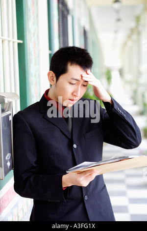 Close-up of a businessman reading mails and looking upset Stock Photo