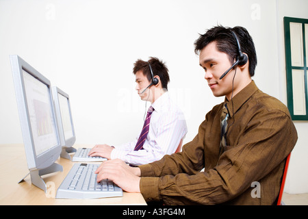 Two customer service representatives working on a computer Stock Photo
