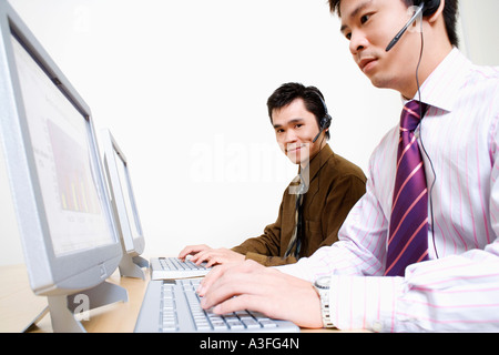 Two customer service representatives working on a computer Stock Photo