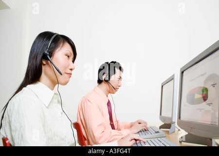 Two customer service representatives working on a computer Stock Photo