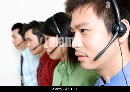 Four customer service representatives talking on headsets Stock Photo