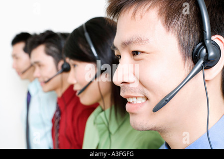 Four customer service representatives talking on headsets Stock Photo