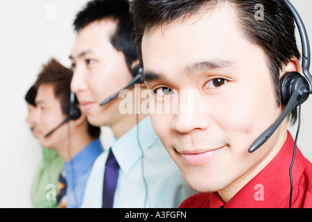 Four customer service representatives talking on headsets Stock Photo