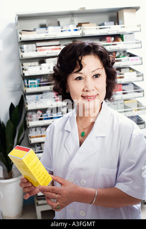 Close-up of a female pharmacist holding medicine in a store room Stock Photo