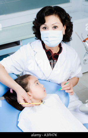 Close-up of a female dentist examining a girl's teeth Stock Photo