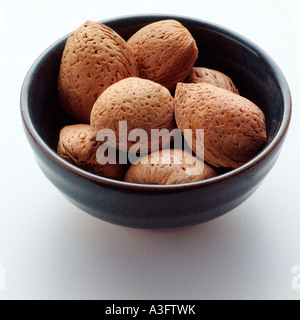 A bowl of almonds on a white background Stock Photo