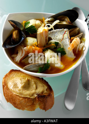 A white bowl of French bouillabaisse on a blue glass background editorial food Stock Photo