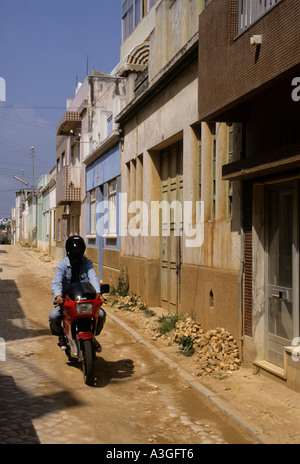 Youth on motorcycle wearing black helmet with visor that does not show face Portimao Algarve Portugal Stock Photo