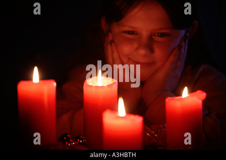 young girl looking happily at the candles of an Advent wreath Stock Photo