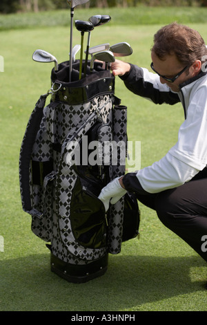Man Looking at Golf Bag Stock Photo