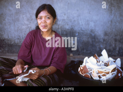 Smiling local woman chopping coconuts for sale Ampenan market Lombok Indonesia Stock Photo