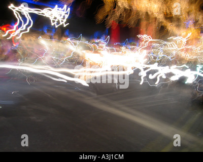 Abstract car light trails from pedestrian viewpoint crossing road at night Stock Photo