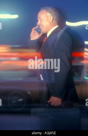 businessman talking on cell phone while rushing to work Stock Photo