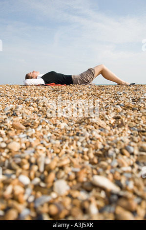 Woman sunbathing on beach Stock Photo
