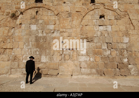 An orthodox Jew standing in front of the now-blocked triple arched Huldah gate in the Southern Wall of the Temple Mount old city Jerusalem Israel Stock Photo