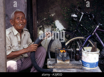 elderly local man at his roadside bicycle repair shop madiun east