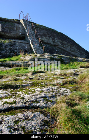 Granite stairs with rusting metal handrails leading up to clear blue sky at the top of Blackinstone Rock near Moretonhampstead Stock Photo