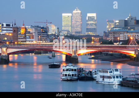 river thames view to blackfriars bridge canary wharf docklands in london england uk united kingdom britain at dusk boats Stock Photo