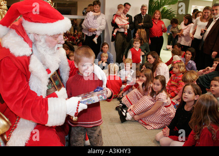 Miami Florida,office Christmas party,Santa Claus,child,children,presents,parents,employee employees worker workers working staff,FL051231179 Stock Photo