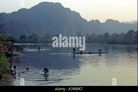 Men in canoes cast nets to catch fish in late afternoon, on the Nam Xong River, Vang Vieng, Laos. DN23 Stock Photo