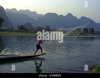 Men in canoes cast nets to catch fish in late afternoon, on the Nam Xong River, Vang Vieng, Laos. DN24 Stock Photo