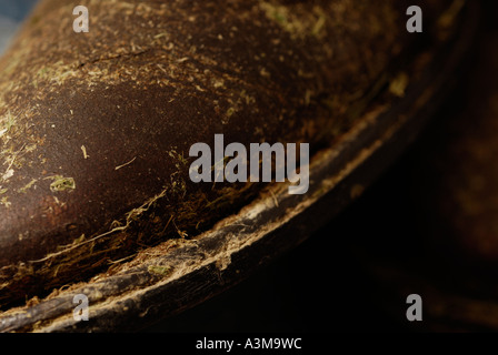 Cowboy boots covered in dried hay and grass and worn out leather Canada Stock Photo