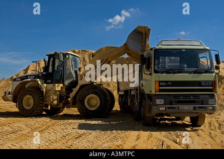 Loading sand into truck from stockpile at quarry for construction purposes Stock Photo