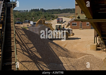 Loading gravel into truck from stockpile at quarry for construction purposes Stock Photo