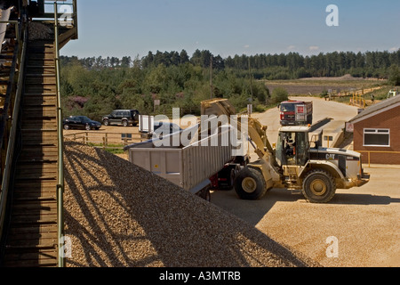 Loading gravel into truck from stockpile at quarry for construction purposes Stock Photo