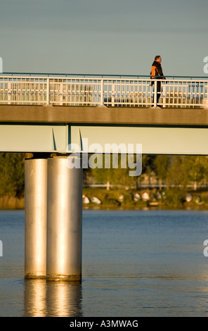 A man walking on a bridge crossing River Oulujoki in Finland Stock Photo