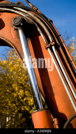 Hydraulics cylinder, piston on an orange excavator's boom Stock Photo